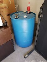 Full view of the blue plastic water barrel showing its cylindrical shape and attached pump.