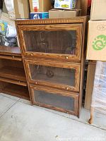 Closed view of the three-tiered barristers bookcase showing wood finish and glass panel doors with knob handles.