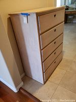 Side view of the wooden chest showing its depth and 5 drawers with heart-shaped handles.