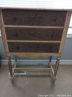 Front view showing burlap front drawers with printed text and two drawer knobs per drawer