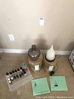 Overview of Scentsy diffuser base, two diffuser shades, and essential oils on the floor with packaging boxes and instruction sheets.