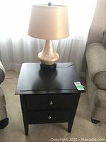 End table with two drawers and table lamp on top