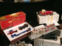 Overview of the lot showing the three models: Franklin Mint red car on white styrofoam, Matchbox truck and engine in red box, and Corgi State Landau horse carriage in plastic case.