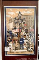 Frontal view of framed Twinings tea towel depicting a detailed vintage London street scene with people, police officer, horse-drawn carriage, and advertising signage.