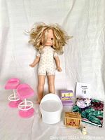 Full lot view including vintage Fisher Price doll and assorted Barbie and dollhouse accessories spread on white backdrop.