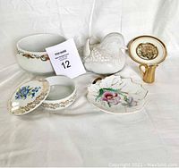 Overall view of all five items in the lot arranged against a white cloth background