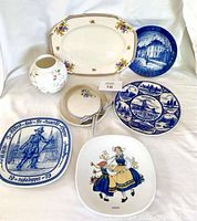 Photo showing all plates and stoneware items in lot from front view