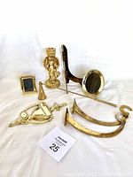 Full lot overview showing all items including two mini picture frames, angel candle holder, brass picture plate holder, candle snuffer, and hooks.