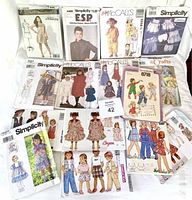 Photo showing assorted vintage sewing pattern envelopes for ladies and kids clothing, various styles and brands.