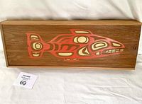 Full view of the rectangular wooden box with a sliding lid featuring a red and cream sockeye salmon design painted on natural wood grain.
