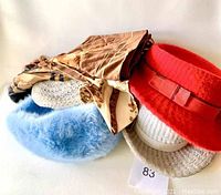 Photo of assorted hats and neck scarves spread out showing colors and materials