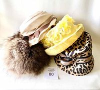 Four vintage ladies hats including a brown fur hat and three fabric hats with different colors and patterns.