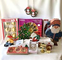 Full lot photo showing vintage Christmas decorations including wooden figures, glass bulbs, brat brass ornaments, and tree topper