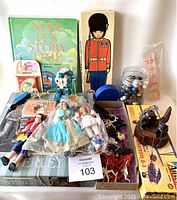 Photo showing the full assortment of items including marbles, dolls, plastic knights, board games, puzzles, and a Transformer toy.