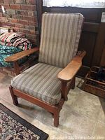 Front view of the vintage wooden Morris chair showing patterned cushions and wooden armrests