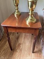 Cherry wood side table showing turned legs and wood grain