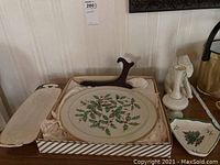 Overview of Lenox and Spode holiday items on wooden surface, including plate, bud vase, elephant figurine, dish and tray.