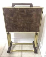 Frontal view of the folded trays inside the rolling stand showing faux parquet wood grain design, gold-tone metal framing, and dark brown faux wood trim on the stand's handle and base.