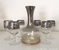 Full set photo showing decanter jug centered with six matching glasses arranged around it