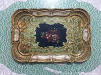 Overall view of rectangular gilt floral tray with scalloped edges and dark blue floral center.