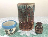 Photo of three vintage Mexican pottery vessels showing the tall cylindrical vessel, mid-sized planter, and small brown vessel with folk art and geometric designs