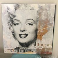 Full frontal image of the square Marilyn Monroe pop art wall art on board showing the full face of Marilyn and text with gold accents.