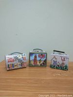 Front view of three vintage metal lunch boxes: 3 Little Pigs on left, G.I. Joe center, Jungle Animals right