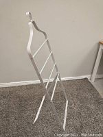 Side view of white foldable metal rack showing structure and foldable design.