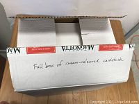 Opened cardboard box labeled as a full box of cream-coloured card stock paper.