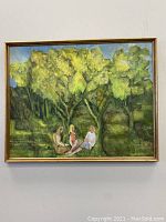 Full view of the framed original painting showing three people sitting under trees outdoors.