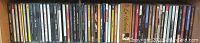 Image of shelf with approximately 36 music CDs by various artists including Leonard Cohen, Louis Armstrong, Ella Fitzgerald, and more.