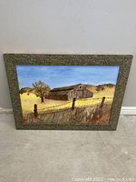 Image of the full framed oil painting showing a barn in yellow and brown fields with fence