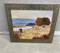 Frontal view of the original oil painting showing a field, winding road, trees, and blue sky, framed in a textured frame.