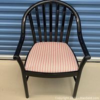 Front view of black metal kitchen chair with vertical slat back, curved armrests, and striped red and white seat upholstery.