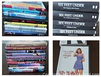 Stack of various DVD titles including classic 80s and 90s films and series, showing colorful spines and some cover art.