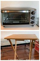 Front view of Black & Decker toaster oven showing stainless steel handle and control knobs, along with wooden foldable table.