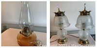 Two matching table lamps with frosted floral glass shades and one amber oil lamp with clear chimney on table