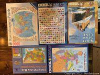 Photo showing six puzzle boxes including a world map, flags of the world, Titanic White Star Line, and maps of Europe and the United States.
