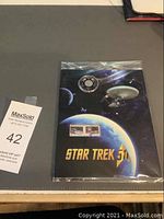 Full view of the sealed 2016 Canada 50-cent Star Trek coin and stamp set in original packaging with cosmic background and 'STAR TREK 50¢' text.