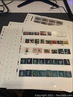 Photo of one stamp collection sheet with Canada Christmas seals singles and strips, showing colorful designs labeled with years 1950, 1952, 1954, 1955