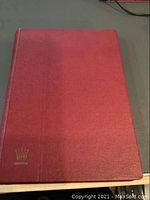 Closed red hardcover stamp album with gilt Lindonia logo on bottom left corner