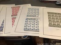 Multiple sheets of Canadian mint stamps with blue and red colors visible.