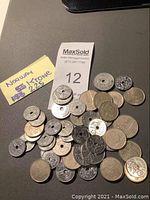 Photo of a group of Norwegian coins with different sizes and metal types, shown with a paper note indicating 225 Krones and auction lot number 12