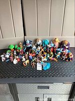 Wide view showing the collection of assorted Disney action figures and figurines spread on a surface.