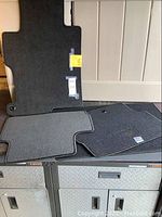 Four carpeted floor mats arranged to show shape and size, each with attachment holes and tags, suitable for 2014 Honda Accord.