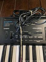 Image showing the top left section of the Casio CTK-2300 keyboard with power and volume controls and connected cables.