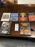 Top-down photo of all six DVDs arranged on a wooden surface showing front covers and artwork for Foreigner, Journey, Aerosmith, and The Heart Pump.