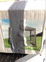 Box label showing image of screen enclosure installed on a gazebo in outdoor grassy setting, demonstrating product use and appearance.