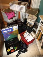 Full view of plastic baskets, digital scale, hairdryer, and packaged items in a corner of a room.