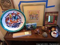 Photo showing all items including plate, framed art, small box, carved animals, stone, mask, mirror, and incense box.